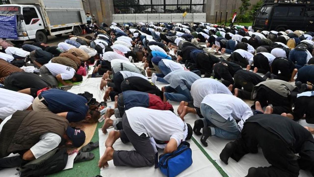 Sejumlah pengunjuk rasa menggelar salat Jumat di depan Gedung DPR, Senayan, Jakarta, Jumat (1/3/2024). Salat Jumat ini digelar sebelum para pengunjuk rasa dari berbagai elemen ini menyampaikan aspirasi dan tuntutannya kepada parlemen.&nbsp;