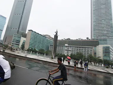 Dua warga bersepeda di kawasan Car Free Day, Jakarta, Minggu (28/2/2016). Hujan yang mengguyur Ibukota sejak semalam hingga pagi membuat kawasan CFD sepi pengunjung. (Liputan6.com/Immanuel Antonius)