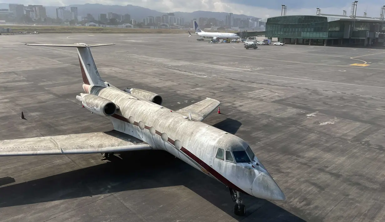 Sebuah pesawat diselimuti abu vulkanik di bandara internasional La Aurora yang telah ditutup akibat letusan di gunung berapi Pacaya di Guatemala City (23/3/2021). (AP Photo / Moises Castillo )