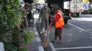 Petugas Satpol PP memberikan sanksi menyapu kepada warga yang tidak menggunakan masker di kawasan Pasar Baru, Jakarta, Jumat (21/8/2020). Sanksi tersebut dilakukan sebagai bagian dari upaya pencehagan penyebaran virus covid-19. (Liputan6.com/Immanuel Antonius)