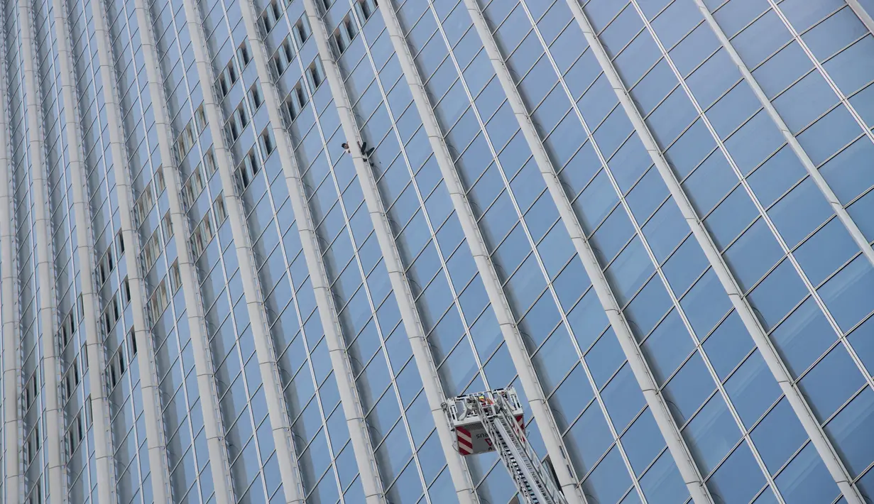 Tangga dinas pemadam kebakaran Korea Selatan berusaha mendekati pemanjat gedung, Alain Robert di Menara Lotte World, Seoul (6/6). Alain Robert dicegat dan diamankan petugas saat berusaha menaklukan Menara Lotte World. (AFP/Ed Jones)