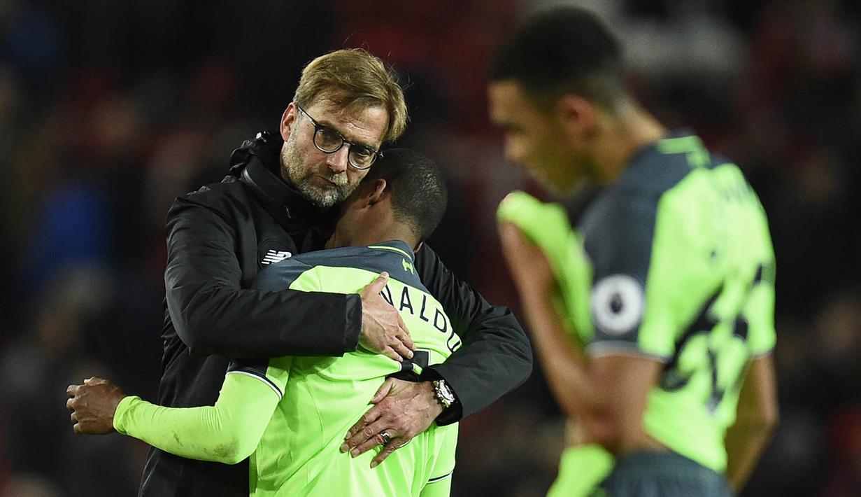 Manajer Liverpool, Juergen Klopp, merangkul Georginio Wijnaldum usai laga melawan Manchester United di Stadion Old Trafford, Inggris, Minggu (15/1/2017). (AFP/Oli Scarff)