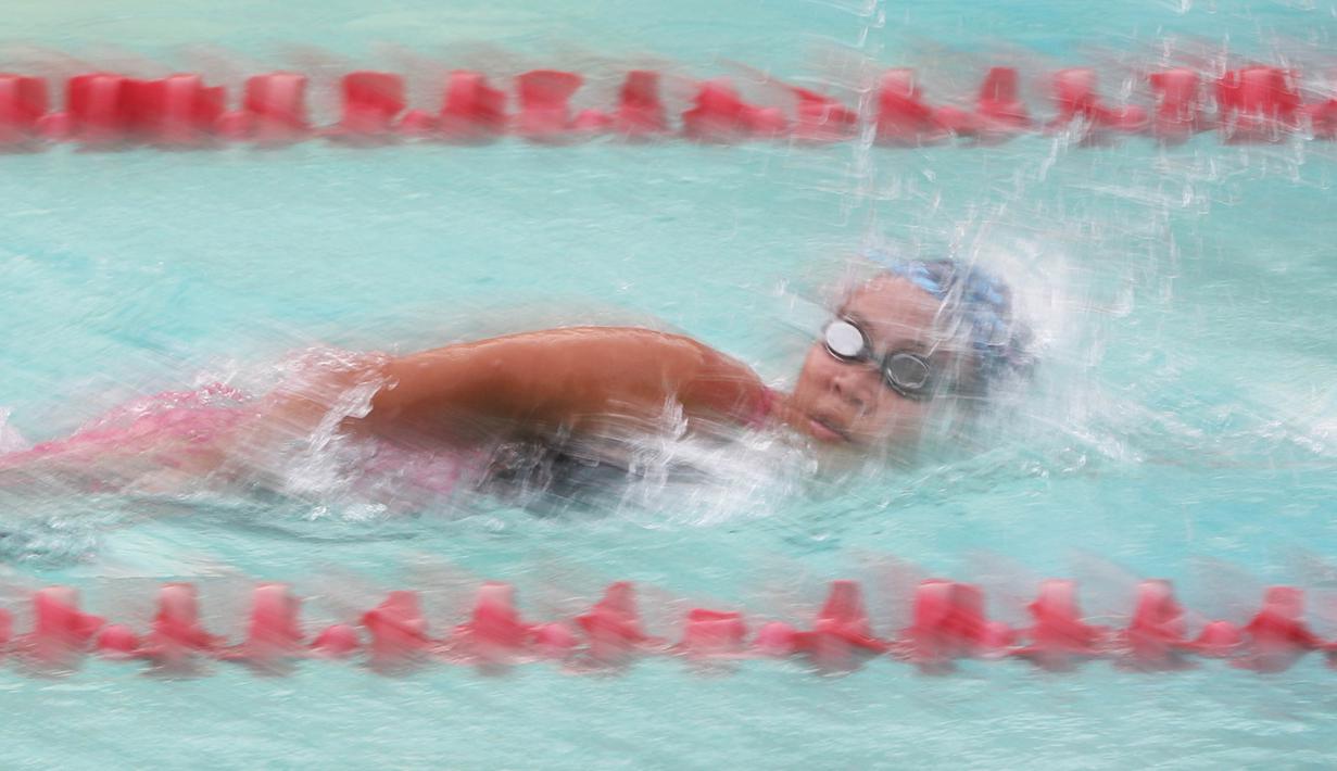 Seorang atlet renang KRAPSI beraksi pada nomor 4x100m gaya bebas putri di Kolam Renang Senayan, Jakarta, Minggu (27/12/2015). (Bola.com/Nicklas Hanoatubun)