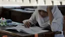Seorang siswi tengah mengerjakan soal UN di hari pertama, Senin (5/5/14). (Liputan6.com/Johan Tallo)