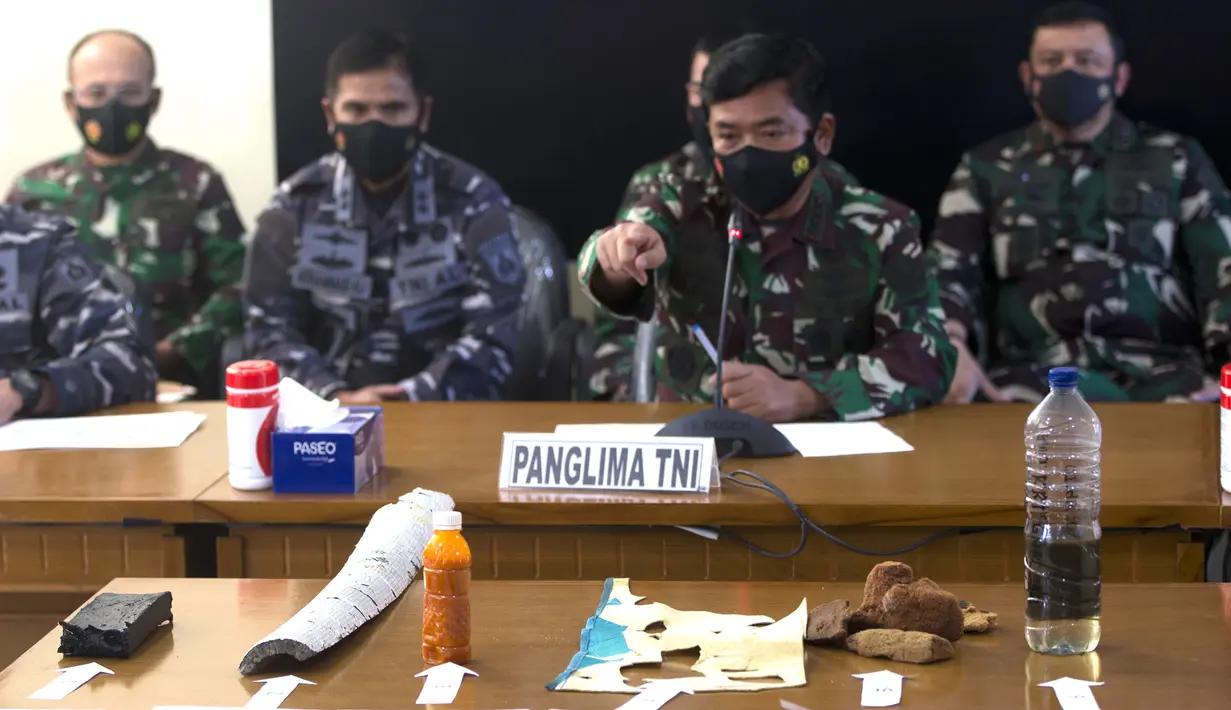 Panglima TNI Hadi Tjahjanto (tengah) menyampaikan keterangan dan menunjukkan puing-puing yang ditemukan dalam operasi pencarian kapal selam KRI Nanggala 402 di Pangkalan Udara Militer Ngurah Rai, Bali, Sabtu (24/4/2021). KRI Nanggala 402 dinyatakan tenggelam atau subsunk. (AP Photo/Firdia Lisnawati)
