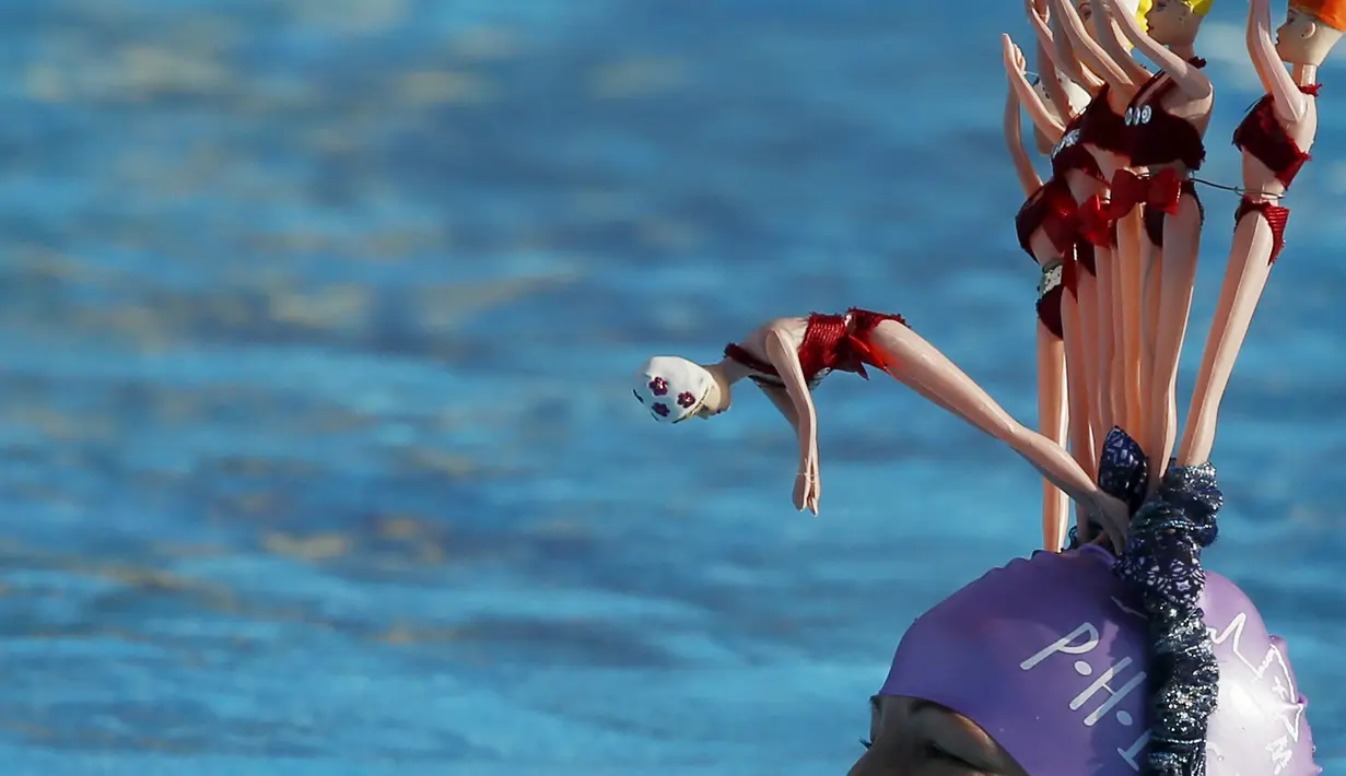 Seorang perenang mengenakan bando berbentuk boneka renang saat ikuti Kejuaraan Renang di Tooting Bec Lido, London,  (24/1/2015). (REUTERS/Luke MacGregor)