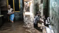 Anak-anak bermain air saat banjir merendam permukiman Kebon Pala, Jatinegara, Jakarta, Minggu (25/10/2020). Tidak adanya tanggul antara permukiman dan Kali Ciliwung menyebabkan banjir yang meluap sejak dini hari tadi lambat surut. (merdeka.com/Iqbal Nugroho)