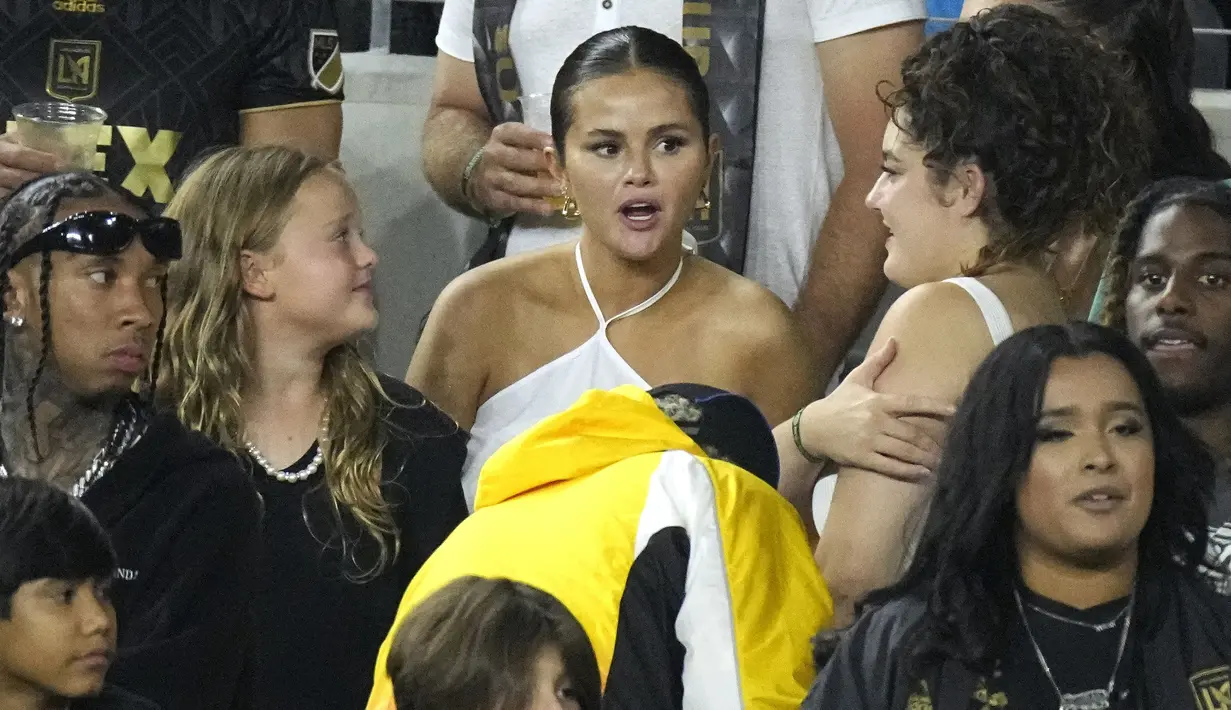 Selebritas Selena Gomez (tengah) dan rapper Tyga (kiri) terlihat saat menyaksikan laga lanjutan Major League Soccer (MLS) antara Los Angeles FC melawan Inter Miami di Stadion BMO, Senin (04/09/2023) WIB. (AP Photo/Mark J. Terrill)