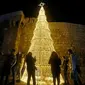 Warga Suriah berkumpul di sekitar pohon Natal di ibu kota Damaskus. (Louai Beshara/AFP)