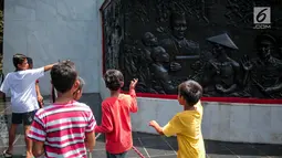 Sejumlah anak melihat relief di Monumen Pancasila Sakti, Lubang Buaya, Jakarta, Minggu (1/10). Bertepatan dengan peringatan hari Kesaktian Pancasila, sejumlah pelajar mengadakan napak tilas ke monumen Kesaktian Pancasila. (Liputan6.com/Faizal Fanani)