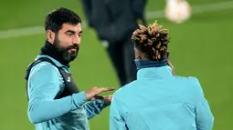 Bek Villarreal Raul Albiol berbicara dengan gelandang Villarreal Samuel Samuel Chukwueze selama sesi latihan di Ciudad Deportiva Villarreal di Vila-Real, Senin (22/11/2021). Villarreal bakal menjamu Manchester United dalam lanjutan Liga Champions, Selasa (23/11) waktu setempat. (JOSE JORDAN / AFP)