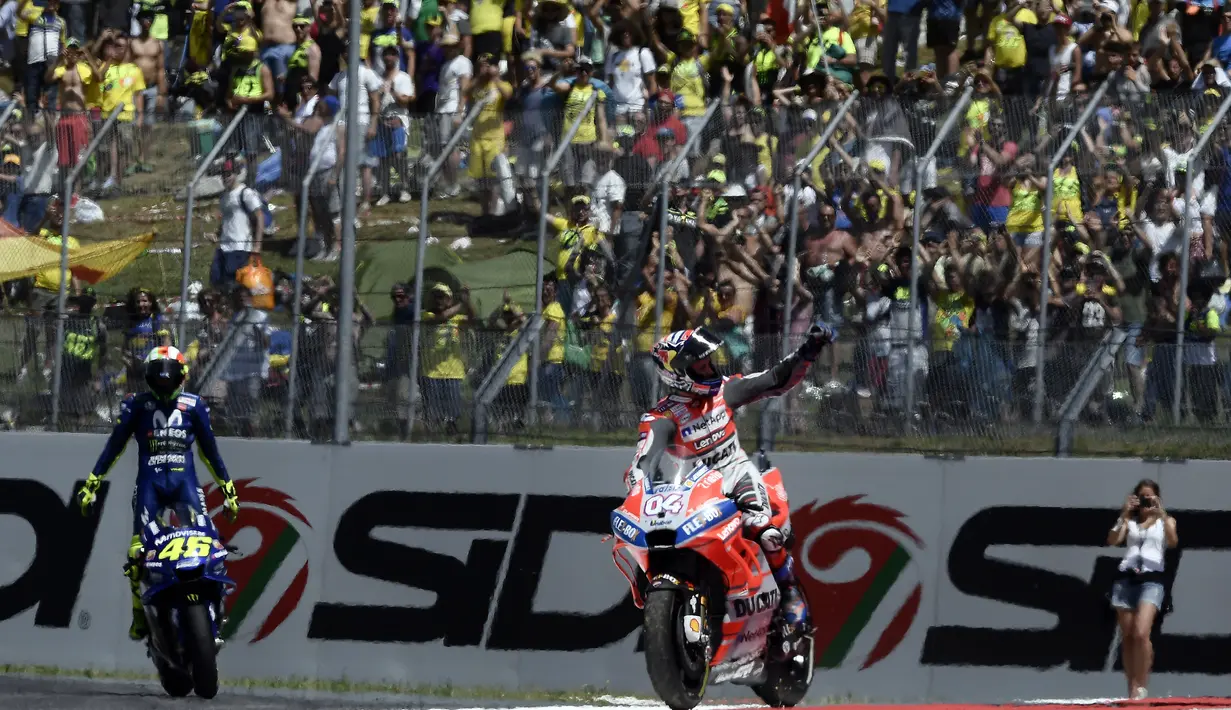 Pembalap Ducati Team, Jorge Lorenzo dan pembalap Italia Movistar Yamaha, Valentino Rossi menyapa penonton setelah memenangkan balapan Moto Grand Prix di Sirkuit Mugello, Italia, Minggu (03/6). (AFP FOTO / Filippo Monteforte)