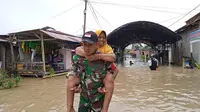 Seorang anggota TNI menggendong seorang ibu untuk dievakuasi ke tempat yang aman dari banjir akibat luapan Sungai Palu, Selasa (6/9/2022). (Foto: Heri Susanto/ Liputan6.com).