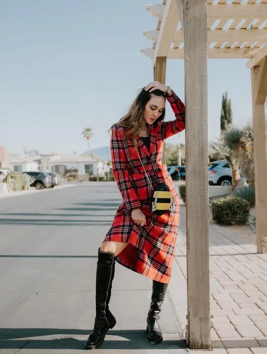 Kala pergi ke Coachella 2022 di Los Angeles, Luna Maya tampil mengenakan plaid coat merah yang dipadu inner hitam, sling bag, serta sepatu boots warna senada. (Instagram/lunamaya).
