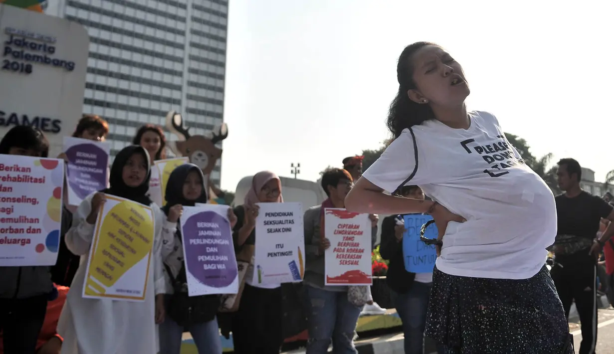 Massa saat menggelar aksi teatrikal menuntut keadilan untuk WA korban pemerkosaan, Jakarta, Minggu (5/8). Massa juga menggelar pembubuhan tanda tangan sebagai bentuk dukungan untuk WA yang dipenjara karena melakukan aborsi. (Merdeka.com/Iqbal S. Nugroho)