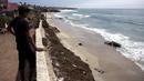 Warga melihat bangkai paus kelabu di Pantai Maria Martha, Baja California, Meksiko (12/9). Bangkai paus dengan kondisi perut tersobek jadi perhatian warga sekitar di lokasi tersebut. (AFP Photo/Guillermo Arias)