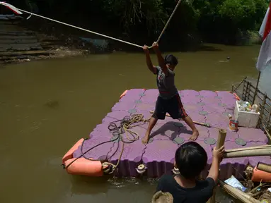 Anak-anak menggunakan perahu eretan di sungai Ciliwung, Jakarta, Selasa (3/11/2020). Perahu eretan di sungai Ciliwung masih bertahan sebagai penghubung Jakarta Timur dan Jakarta Selatan Selatan. (merdeka.com/Imam Buhori)