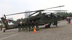 Tim penerbang berada di sisi helikopter Apache yang dipamerkan pada pameran Alat Utama Sistem Persenjataan TNI di Kawasan Monas, Jakarta, Kamis (27/9). TNI memiliki delapan helikopter Apache AH 64E buatan Amerika Serikat. (Liputan6.com/Helmi Fithriansyah)