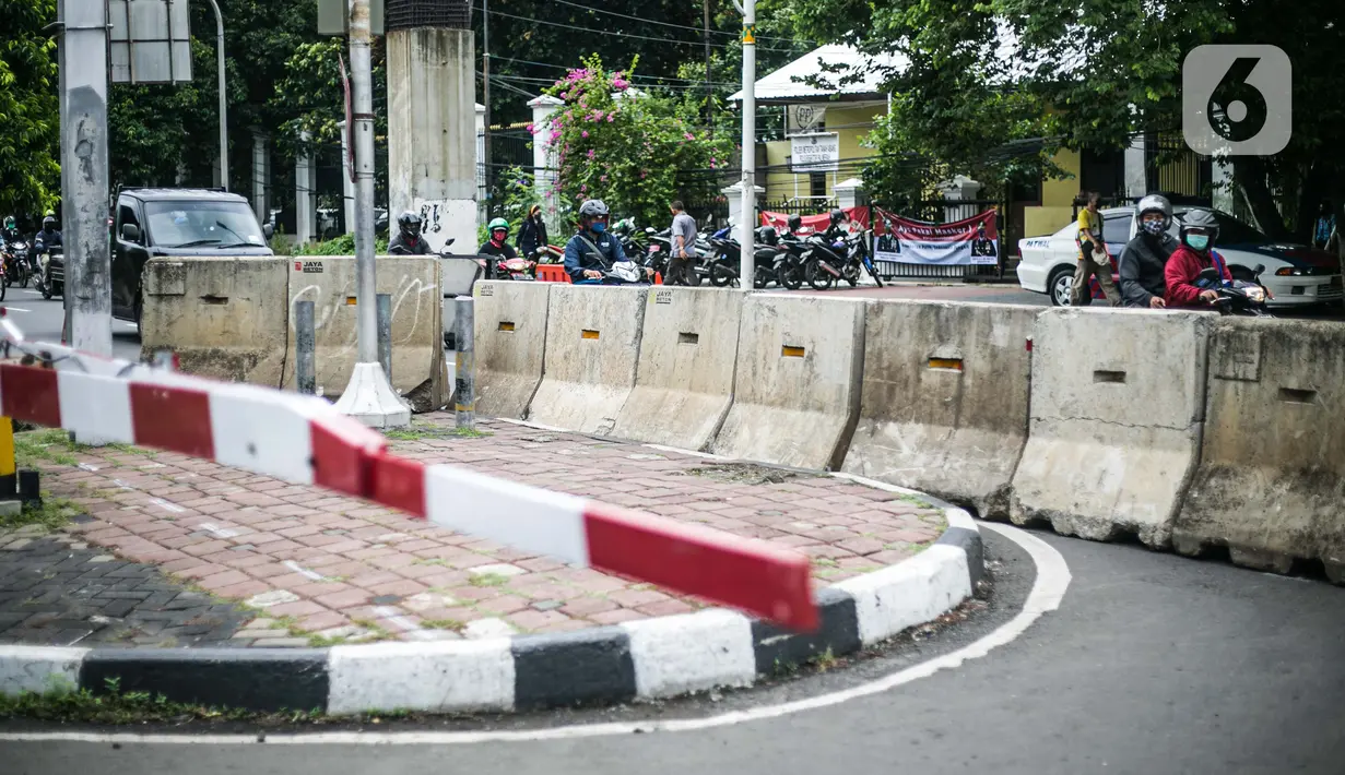 Kendaraan melintas di samping perlintasan sebidang yang sudah ditutup di sekitar Stasiun Palmerah, Jakarta, Senin (30/11/2020). Dinas Perhubungan DKI resmi menutup perlintasan sebidang kereta api tersebut terkait adanya program penataan tahap dua di Stasiun Palmerah. (Liputan6.com/Faizal Fanani)