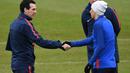 Pelatih PSG, Unai Emery (kiri) bersalaman dengan Angel Di Maria saat sesi latihan jelang leg kedua Liga Champions melawan Real Madrid di Ooredoo training center, Saint-Germain-en-Laye,Paris, (5/3/2018). Leg pertama PSG kalah 1-3. (AFP/Franck Fife)
