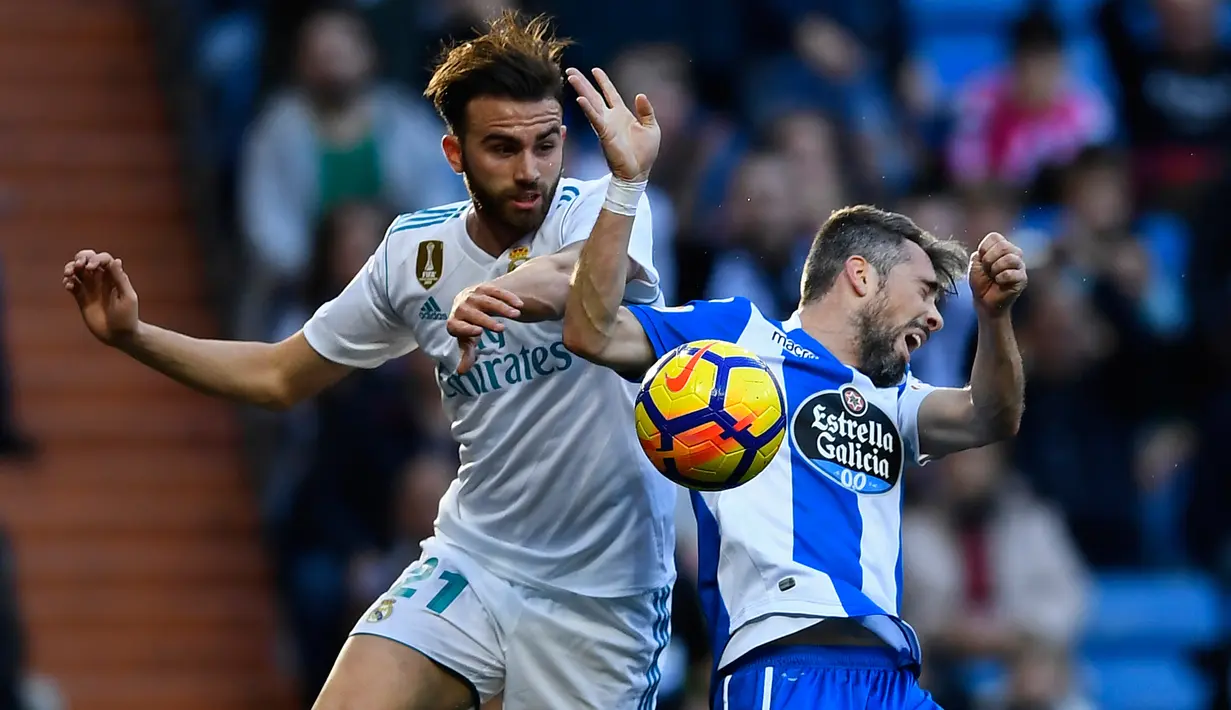 Pemain Real Madrid, Borja Mayoral berebut bola dengan pemain Deportivo La Coruna, Luisinho dalam lanjutan La Liga Spanyol di Santiago Bernabue, Senin (22/1). Real Madrid membukukan kemenangan 7-1 atas Deportivo La Coruna. (OSCAR DEL POZO/AFP)