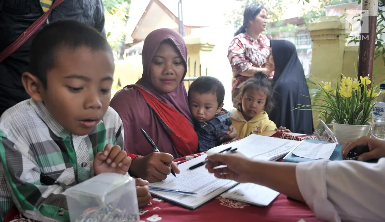Warga antre saat mengikuti Bina Kependudukan (Biduk) di Pal Putih, Kramat, Senen, Jakarta, Rabu (10/7/2019). Biduk melayani pembuatan Kartu Indonesia Anak (KIA) serta Akta Kelahiran, dan pembaharuan KTP. (merdeka.com/Iqbal Nugroho)
