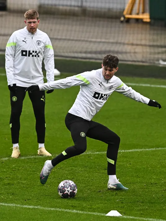 Pemain Manchester City Kevin De Bruyne (kiri) dan John Stones menjalani sesi latihan di tempat latihan Manchester City di Manchester, Inggris, 13 Maret 2023. Manchester City akan menghadapi RB Leipzig pada pertandingan sepak bola leg kedua babak 16 besar Liga Champions. (Paul ELLIS/AFP)