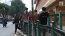 Penumpang melompati pagar pembatas untuk keluar dari Stasiun Cikini di Jakarta, Jumat (22/3). Jauhnya akses pintu masuk dan keluar stasiun menyebabkan sebagian orang mempersingkat waktu dengan melompat pagar pembatas. (Liputan6.com/Immanuel Antonius)