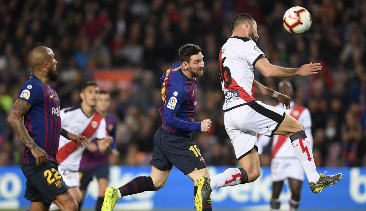 Pemain Barcelona, Lionel Messi (tengah), duel udara dengan pemain Rayo Vallecano, Jordi Amat (kanan), dalam pertandingan lanjutan La Liga 2018/2019 yang berlangsung di Camp Nou stadium, Sabtu (9/3/2019). (AFP/Lluis Gene)