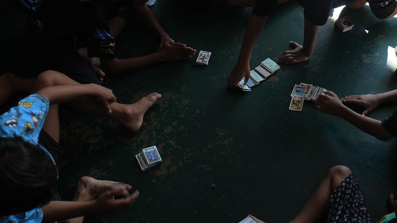 Sejumlah anak bermain kartu kuartet atau kartu gambar di kawasan Pasar Jatinegara, Jakarta, Sabtu (20/4/2024). Siapa yang tak kenal dengan permainan kartu kuartet atau kartu gambar? Permainan jadul ini sudah menemani masa kanak-kanak bagi banyak orang, te