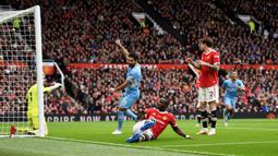 Manchester City sudah unggul 1-0 pada menit ke-7. Eric Bailly yang berusaha menghalau umpan silang yang dikirimkan Joao Cancelo dari sebelah kanan pertahanan Manchester United, intersepnya justru membuat bola meluncur deras masuk ke gawang David De Gea. (AFP/Oli Scarff)