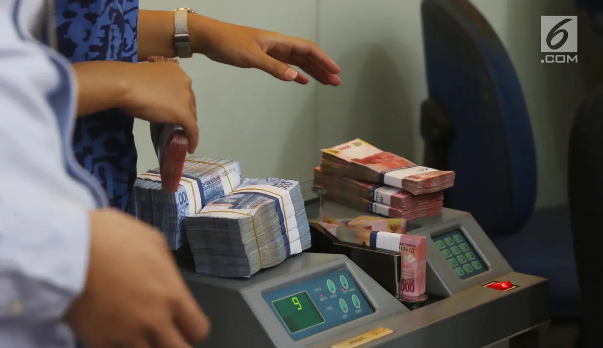 Petugas menghitung uang rupiah di cabang Bank Mandiri Pertamina UPMS III, Jakarta, Rabu (28/6). Bank Mandiri mengoperasikan 319 kantor cabang se-Indonesia secara bergantian pada musim liburan Idul Fitri 26-30 Juni 2017. (Liputan6.com/Angga Yuniar)