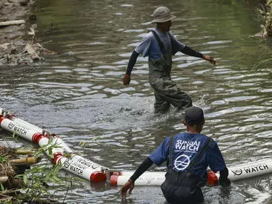 Anggota komunitas Sungai Watch memasang penghalang sampah baru di sebuah sungai di distrik Kerobokan, Bali, pada 14 Desember 2023. (David GANNON/AFP)