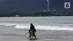 Warga bermain air di Pantai Pelabuhan Ratu, Kabupaten Sukabumi, Jawa Barat, Jumat (12/11/2021). Penerapan Pemberlakuan Pembatasan Kegiatan Masyarakat (PPKM) Level 1 membolehkan objek wisata kembali buka, salah satunya Pantai Pelabuhan Ratu. (Liputan6.com/Johan Tallo)