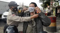 Anggota polisi dari Polsek Parung membantu memasangkan masker kepada pengendara sepeda motor di depan Polsek Parung, Kabupaten Bogor, Jawa Barat, Rabu (2/9/2020). Pembagian masker gratis setiap usai apel ini inisiatif anggota sejak masa pandemi COVID-19. (merdeka.com/Dwi Narwoko)