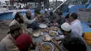 Nelayan berbuka puasa selama bulan suci Ramadhan, di galangan kapal, di Karachi, Pakistan, Selasa (20/4/2021). (AP Photo / Fareed Khan)