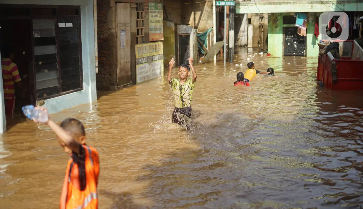 Anak-anak bermain di tengah banjir yang merendam kawasan Rawajati, Jakarta Selatan, Sabtu (8/2/2020). Hujan yang terjadi semalaman menyebabkan Sungai Ciliwung kembali meluap hingga membuat rumah warga di kawasan tersebut terendam air setinggi 50 cm hingga 1 m. (Liputan6.com/Immanuel Antonius)