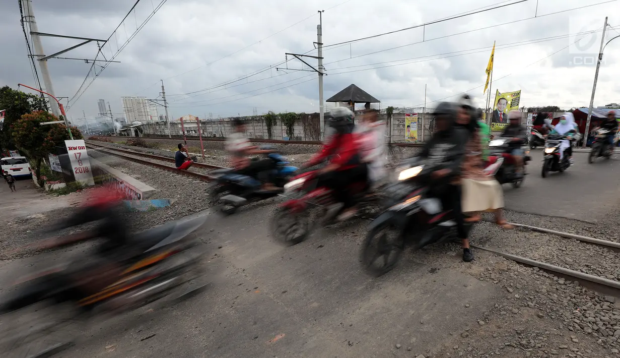 Pengendara motor melewati perlintasan kereta api tanpa palang pintu di kawasan Kelingkit, Rawa Buaya, Jakarta, Selasa (26/2). Rel kereta tanpa adanya palang pintu penutup ini sangat berbahaya karena bisa menyebabkan kecelakaan. (Liputan6.com/Johan Tallo)