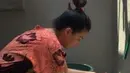 "Bunda lagi cuci baju," tulis Ruben dalam keterangan foto saat Sawendah sedang mencuci baju putrinya. Tidak menggunakan mesin cuci, tapi mencuci dengan tangan dan papan pengilasan. (Instagram/ruben_onsu29)