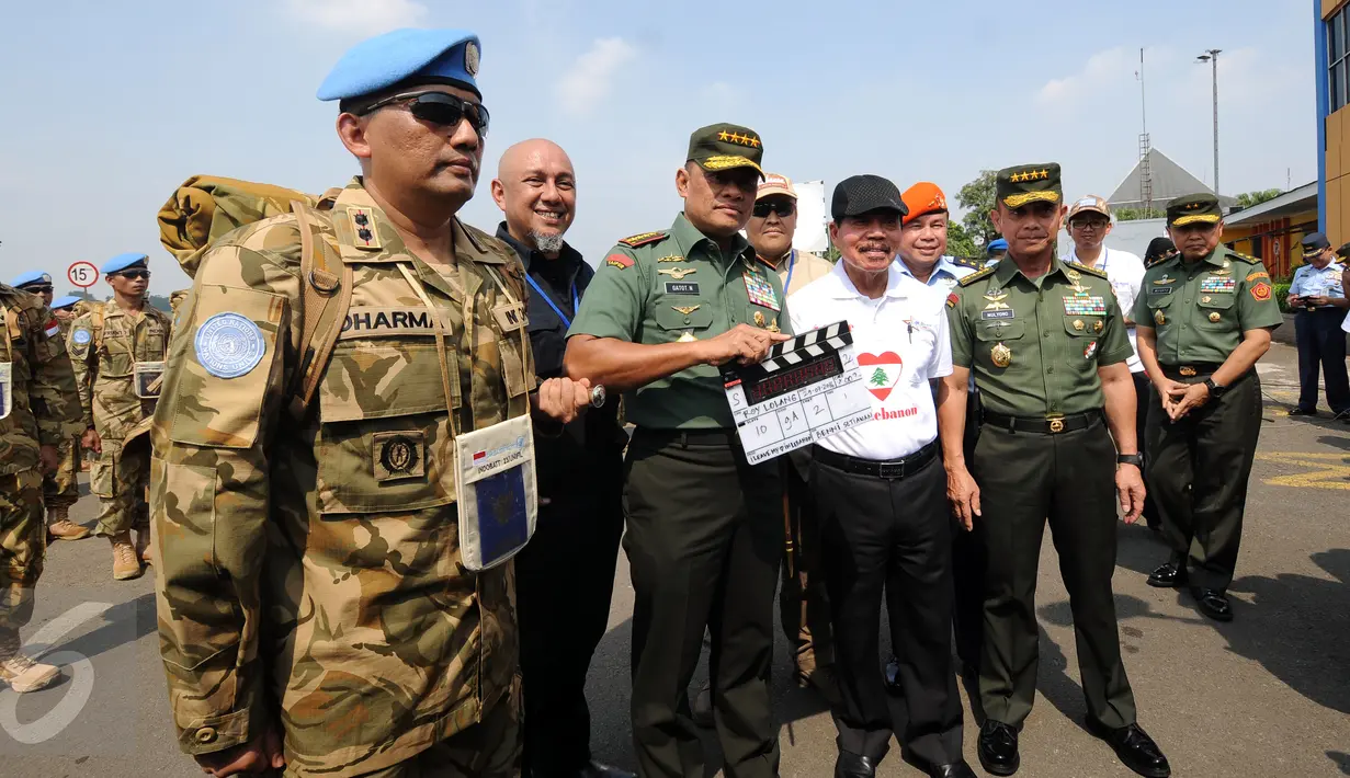 Panglima TNI Jenderal TNI Gatot Nurmantyo (tengah) mengetuk papan scene saat meninjau syuting perdana film ”Garuda 23” di Bandara Halim Perdanakusuma, Jakarta, Jumat (29/7). Film ini bertema misi perdamaian pasukan TNI. (Liputan6.com/Helmi Fithriansyah)