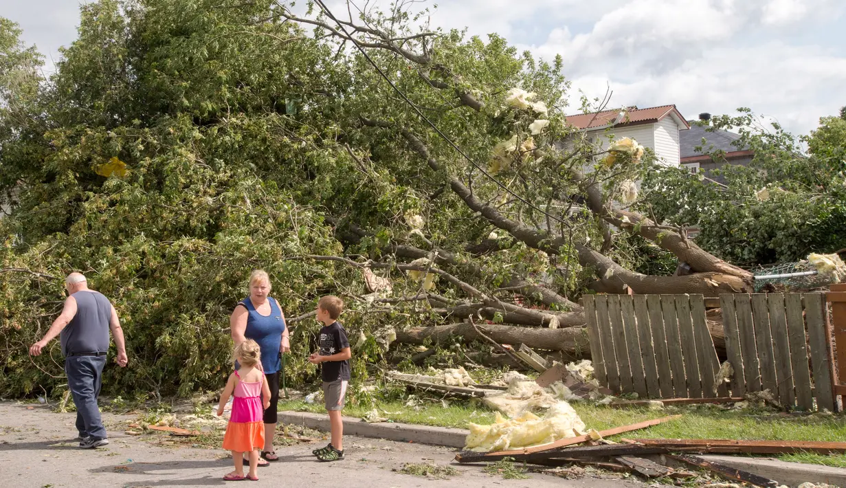 Warga melihat kerusakan rumahnya yang dihantam tornado di Lachute, Barat laut Montreal, Quebec, Rabu (23/8). Untungnya, tidak ada korban jiwa atas kejadian ini. (Ryan Remiorz/The Canadian Press via AP)