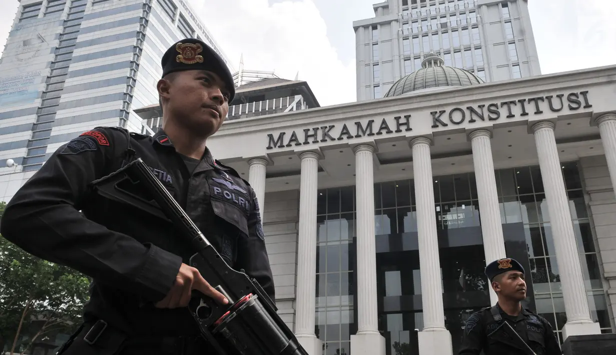 Personel kepolisian saat berjaga di depan Gedung Mahkamah Konstitusi (MK), Jakarta, Rabu (26/6/2019). Kepolisian memperketat penjagaan di sekitar Gedung MK dengan kawat berduri, kendaraan lapis baja, serta ratusan personel. (merdeka.com/Iqbal S. Nugroho)