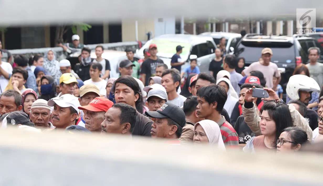 Warga berkerumun di depan lokasi pembunuhan wanita yang ditemukan tewas di dalam lemari di kawasan Mampang, Jakarta, Jumat (23/11). Polres Jaksel menggelar rekonstruksi setelah penyidik menggali keterangan pelaku. (Liputan6.com/Helmi Fithriansyah)