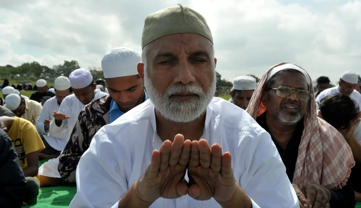Umat Muslim India berdoa memohon turun hujan di depan Danau Himayat Sagar di Hyderabad, India, Minggu (21/7/2019). Dampak angin muson mengakibatkan hasil panen pertanian musiman warga berkurang karena pengaruh kemarau yang panjang. (AFP Photo/Noah Seelam)