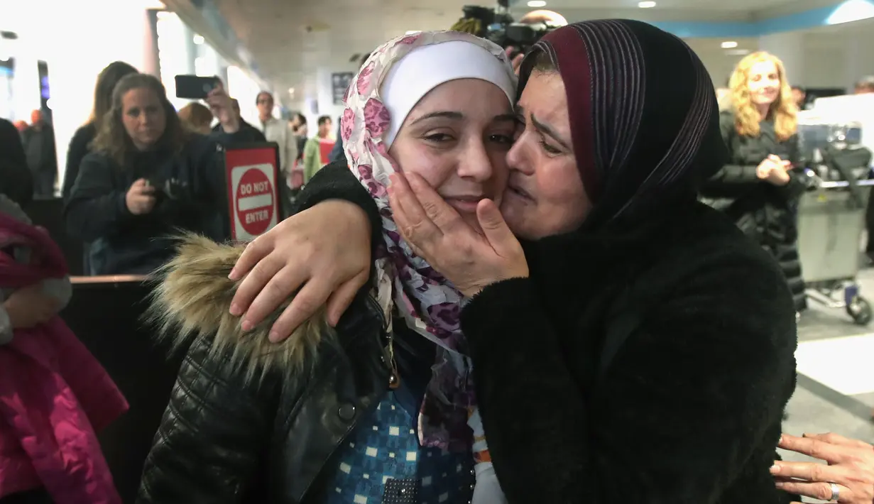 Pengungsi asal Suriah Baraa Haj Khalaf, disambut oleh ibunya Fattuom Bakir saat tiba di bandara Internasional O'Hare, AS, Rabu (7/2). Baraa dan keluarganya harus menjalani introgasi panjang agar bisa melewati otoritas bandara. (AFP Photo/ Scott Olson)