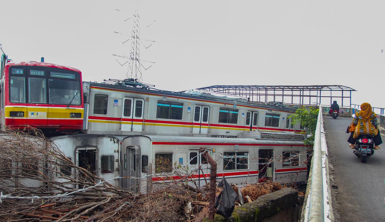 Penumpukan sementara di Depo Depok dilakukan sebagai bagian dari tahapan perucutan sarana KRL sebelum seluruh gerbong dipindahkan ke lokasi konservasi di Stasiun Pasirbungur, Subang, Jawa Barat. Tampak dalam foto, warga melintas di jalan layang dekat Depo Kereta Rel Listrik (KRL) di Jalan Kampung Rawageni, Cipayung, Kota Depok, Jawa Barat, Selasa (20/01/2026). (Merdeka.com/Arie Basuki)