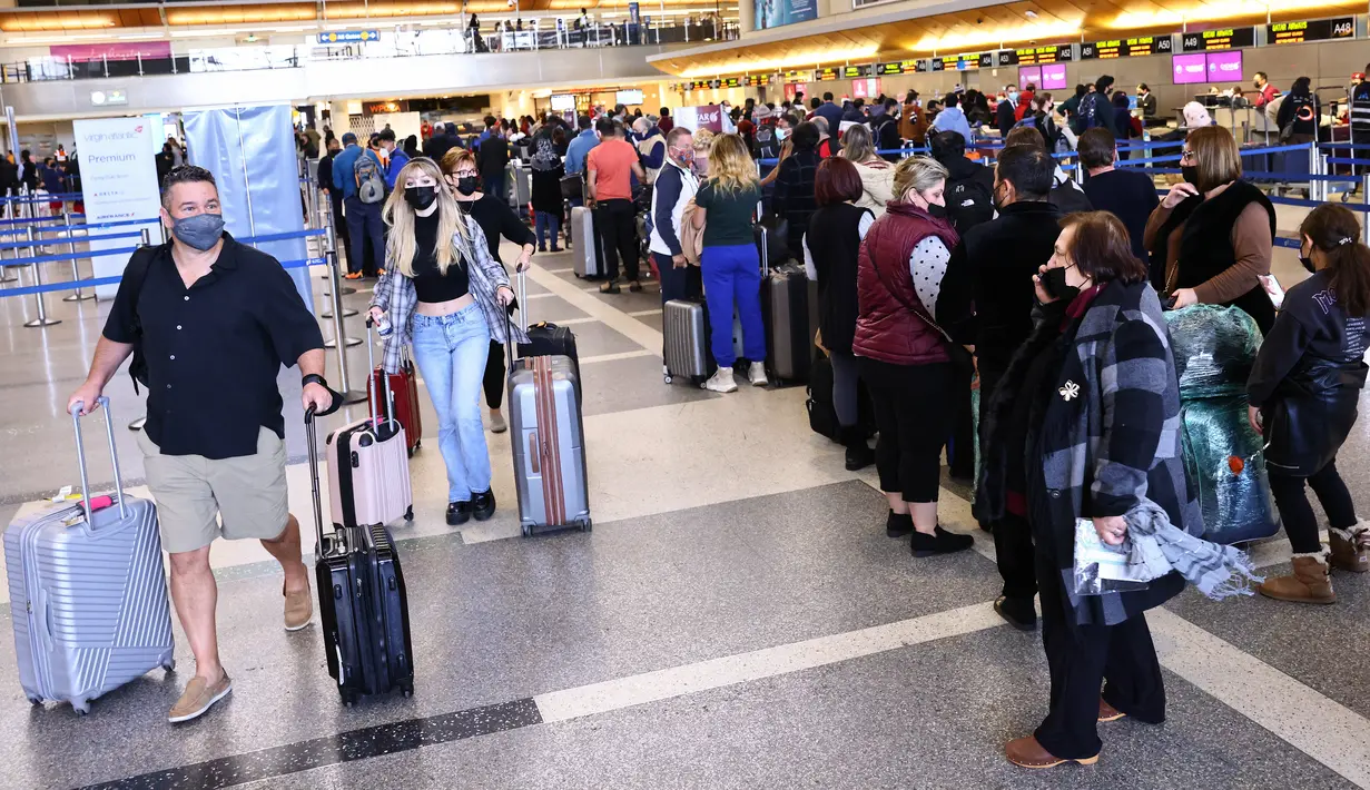 Pelancong berkumpul di terminal internasional Bandara Los Angeles (LAX) di tengah lonjakan kasus varian omicron, Selasa (21/12/2021). AAA memperkirakan lebih dari 109 juta orang Amerika akan melakukan perjalanan selama musim liburan antara 23 Desember dan 2 Januari. (MARIO TAMA/Getty Images via AFP)