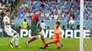 Pada proses terjadinya gol pertama, Cristiano Ronaldo berupaya menggapai umpan silang yang diberikan Bruno Fernandes dan bola akhirnya masuk ke dalam gawang Uruguay yang dijaga Sergio Rochet. (AP Photo/Petr David Josek)