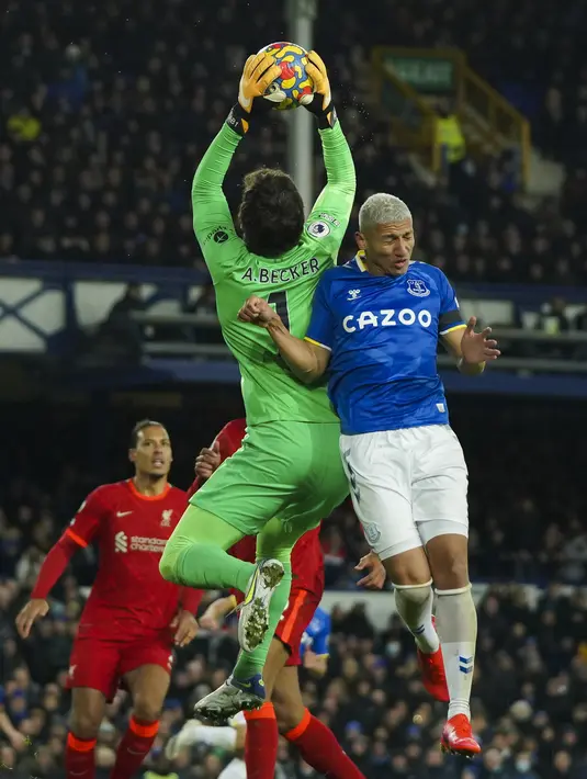 Penjaga gawang Liverpool Alisson Becker berusaha menangkap bola dari sundulan penyerang Everton, Richarlison pada pertandingan lanjutan Liga Inggris di Goodison Park di Liverpool, Inggris, Kamis (2/12/2021). Liverpool menang telak atas Everton 4-1. (AP Photo/Jon Super)