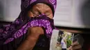 Narsiah, ibu kandung Wanipah menunjukan foto anaknya, di sekretariat SPILN, Jakarta, Minggu (17/5). Narsiah menyampaikan permohonan bantuan kepada Presiden Jokowi terkait ancaman hukuman mati TKI Wanipah. (Liputan6.com/Faizal Fanani)